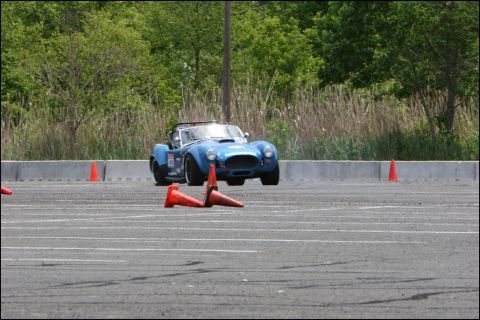 2001 Mercury Grand Marquis - A blue AC Cobra replica is seen on an autocross course, maneuvering around traffic cones.