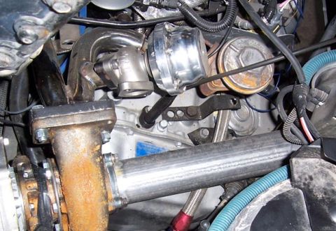 1988 Pontiac Fiero - This image shows a close-up view of engine components, including a turbocharger and exhaust manifold.