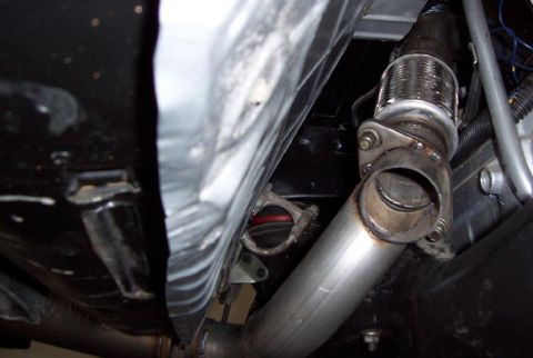 1988 Pontiac Fiero - Close-up of an exhaust system component on a vehicle.