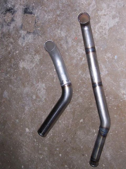 1988 Pontiac Fiero - Two exhaust pipes are shown against a concrete background, with one pipe exhibiting welding marks.