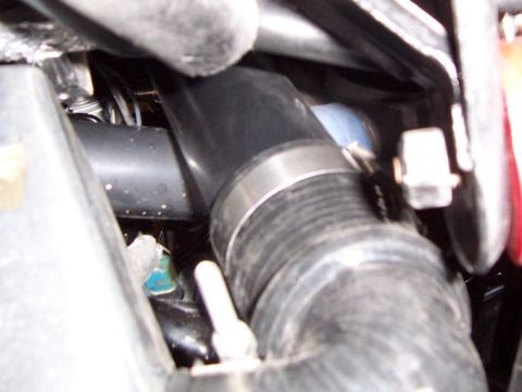 1988 Pontiac Fiero - Engine hose clamp detail. The image shows a close-up of a clamp securing a rubber hose within an engine bay.