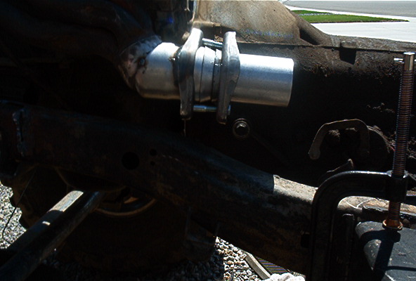 Close-up of a metal exhaust pipe section being clamped for repair
