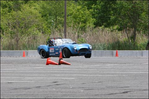 2001 Mercury Grand Marquis - A blue sports car navigates an autocross course with orange cones on the track.