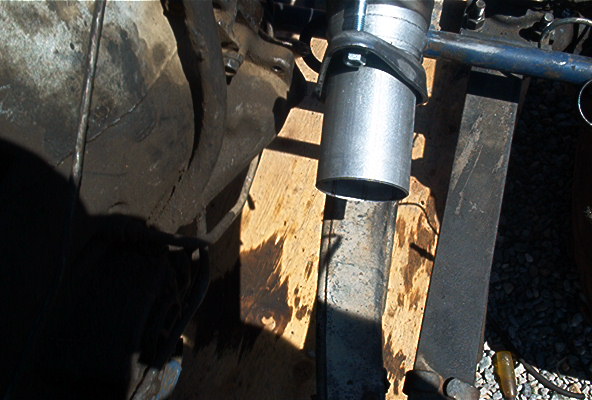 Close-up of a metal exhaust pipe section attached to a vehicle's undercarriage