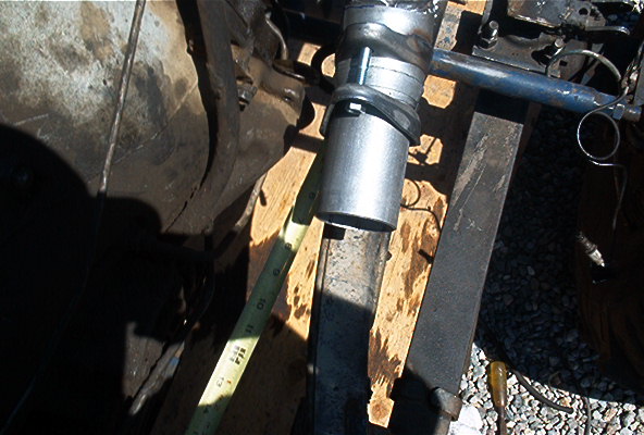 Close-up of exhaust pipe being installed with a tape measure nearby