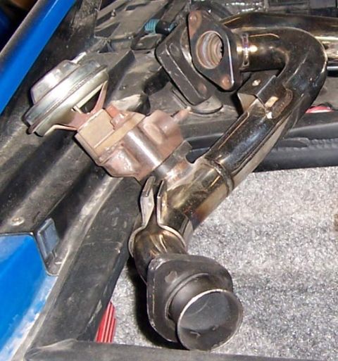 1988 Pontiac Fiero - Close-up of an exhaust pipe and wastegate actuator assembly, with a Supermotors.net watermark visible.