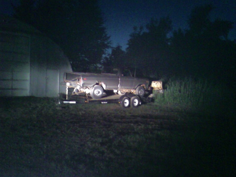 Old pickup truck on a trailer at night