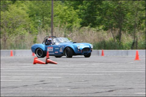 2001 Mercury Grand Marquis - A blue convertible race car navigates an autocross course marked by orange cones.