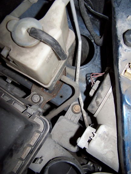 2000 Ford Crown Victoria - Close-up view of various engine bay components, including a white reservoir and associated hoses and wiring.