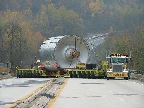 Oversize load on trailer with Peterbilt truck, traffic in background