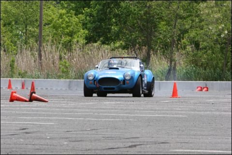 2001 Mercury Grand Marquis - Blue AC Cobra replica navigates an autocross course with orange cones.