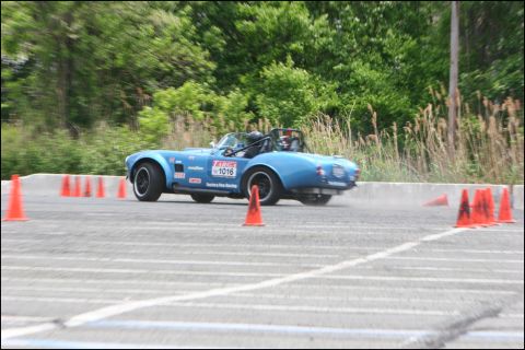 2001 Mercury Grand Marquis - Blue convertible sports car navigates an autocross course with orange cones.