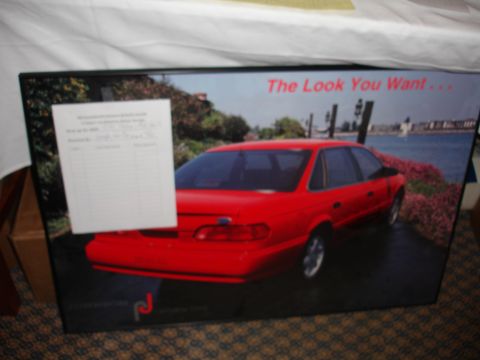 1993 Ford Taurus - A red sedan is pictured with a waterfront background and a paper attached to the image.