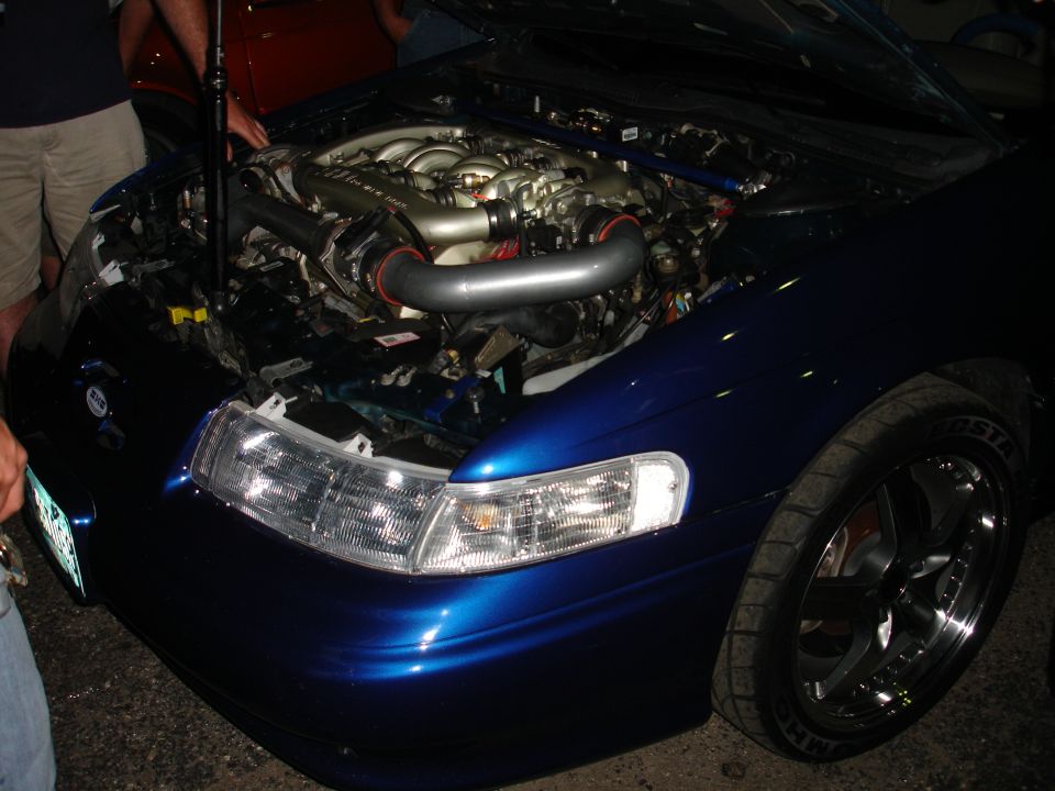 Blue car's engine bay with aftermarket intake, front quarter view