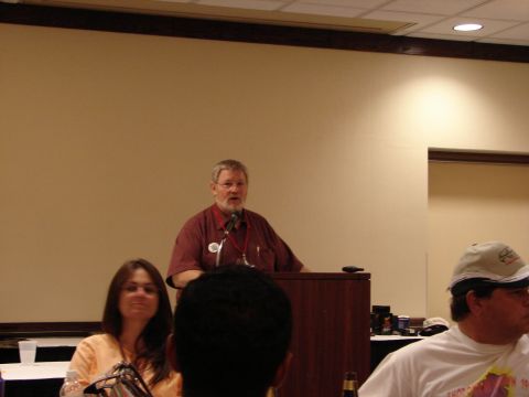 1993 Ford Taurus - A speaker addresses an audience during an event, with attendees visible in the foreground.