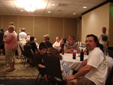1993 Ford Taurus - Attendees mingle and sit at tables during an indoor event, with bottles of drinks on the tables.