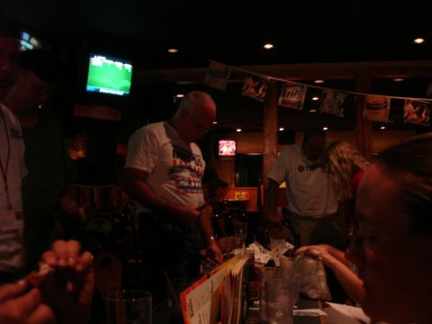 1993 Ford Taurus - People gather inside a dimly lit establishment with multiple televisions displaying sports.