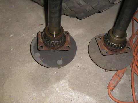 1990 Ford Bronco - Close-up view of front axle hubs and bearings, likely for a 4x4 vehicle, resting on a concrete surface.