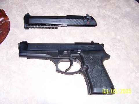 2000 Nissan Xterra - A disassembled Beretta pistol and its slide are shown on a textured surface.