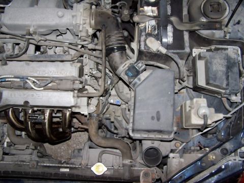 2000 Ford Crown Victoria - Close-up view of a Mazda engine bay, showing the valve cover and exhaust manifold.