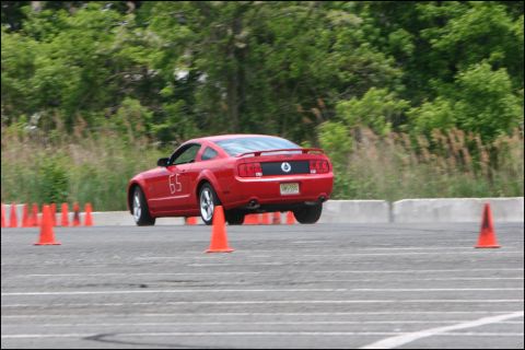 2001 Mercury Grand Marquis - A red Ford Mustang navigates an autocross course, with its rear visible as it turns.