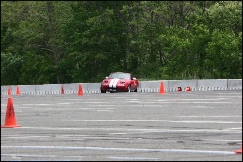 2001 Mercury Grand Marquis - A red convertible with white racing stripes navigates an autocross course marked by orange cones.