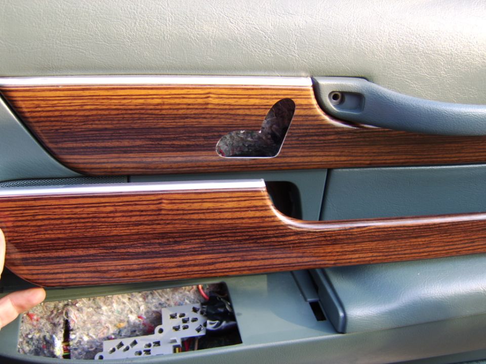 Stock door woodgrain trim piece removed, 8 way power seat switch cutout trim installed