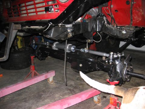 1970 Ford Bronco - The front suspension and steering system of a vehicle are shown, with a red grille in the background.