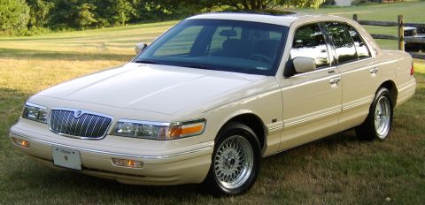 1996 Mercury Grand Marquis - Cream-colored 1996 Mercury Grand Marquis sedan with chrome grille and wire wheels.