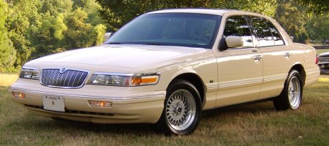 1996 Mercury Grand Marquis - This 1996 Mercury Grand Marquis is shown in a 3/4 front view, parked on grass with trees in the background.