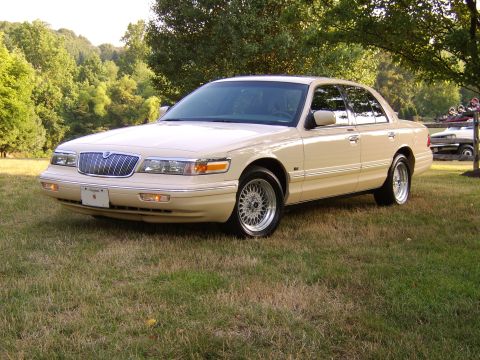 1996 Mercury Grand Marquis - This 1996 Mercury Grand Marquis is parked outdoors on a grassy area with trees behind it.
