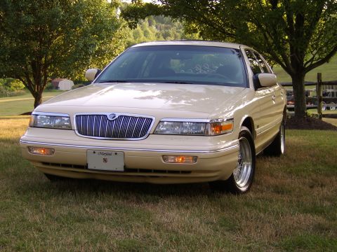 1996 Mercury Grand Marquis - A tan 1995 Mercury Grand Marquis is parked on a grassy lawn with trees in the background.