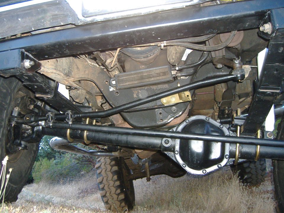 Undercarriage view of a lifted truck showing axle, driveshaft and steering