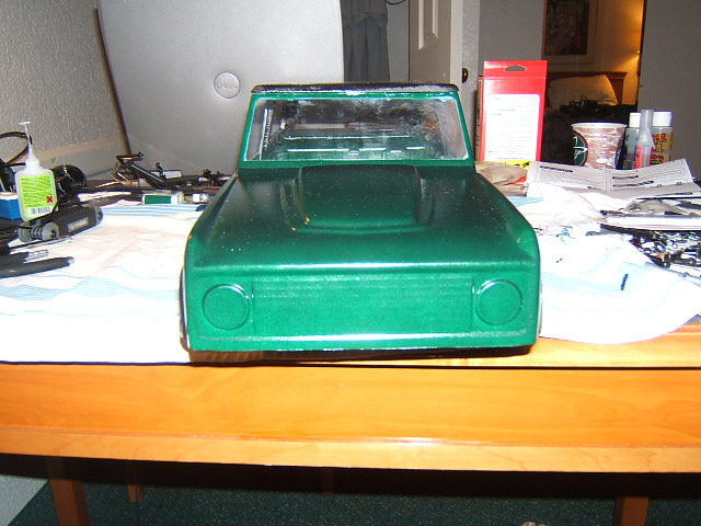 Green toy truck body with round headlights and a raised hood section