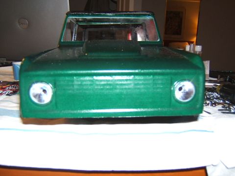 1988 Ford Bronco - This is a front view of a green toy truck, possibly a model, with visible headlights and a hood scoop.