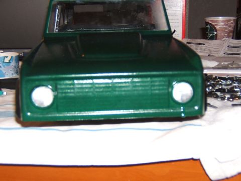 1988 Ford Bronco - A green toy truck body sits on a white cloth, with parts and instructions visible in the background.