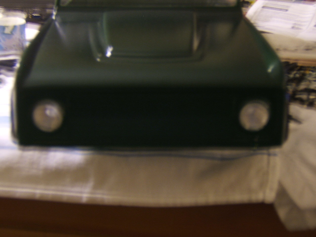 Dark green vehicle hood with two round headlights visible