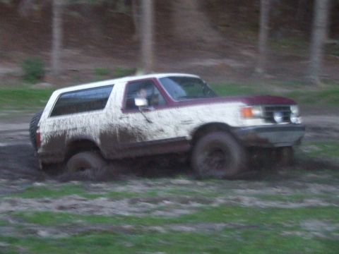 1990 Ford Bronco - This Ford Bronco is deep in the mud, with its tires partially submerged.