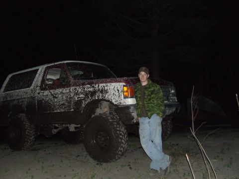 1990 Ford Bronco - A muddy 1990 Ford Bronco is shown in this nighttime photo with a person standing beside it.