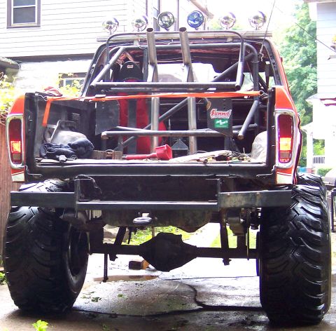 1978 Ford Bronco - This modified 1978 Ford Bronco features a custom roll cage and oversized tires, viewed from the rear.