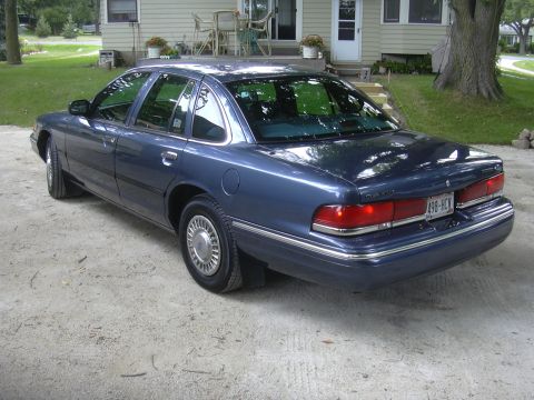 1996 Ford Crown Victoria - Blue 1996 Ford Crown Victoria seen from the rear quarter angle on a gravel surface.