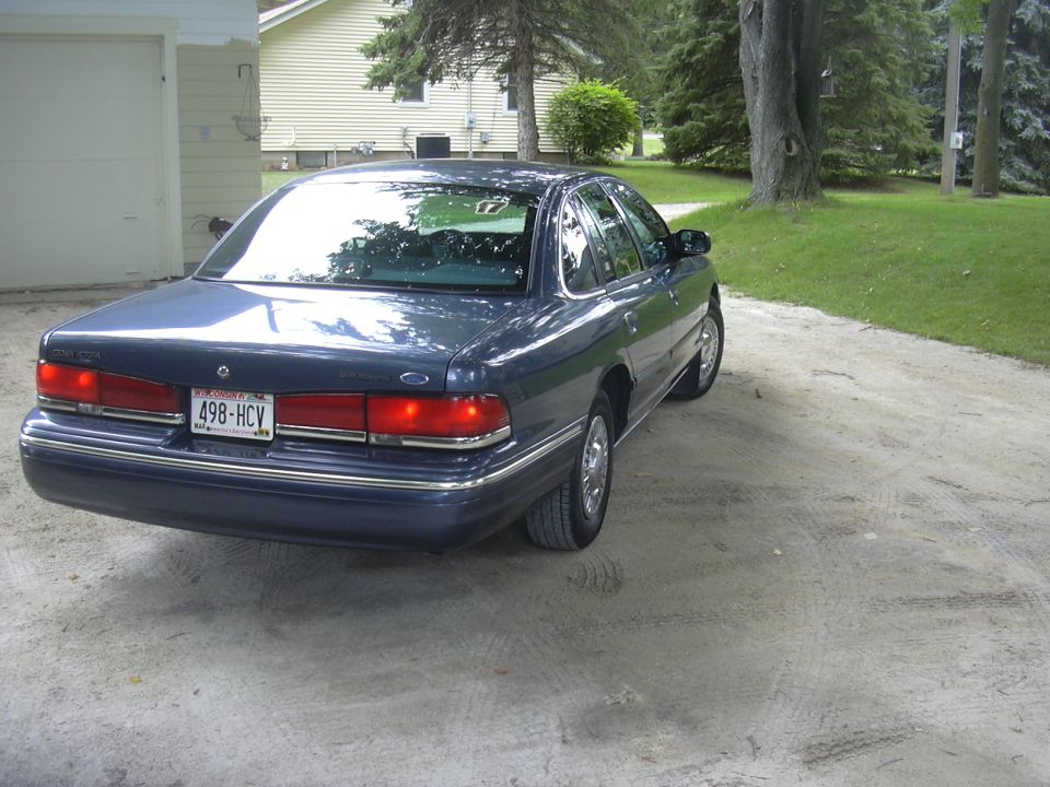 Dark blue 1996 Ford Crown Victoria parked on a dirt driveway