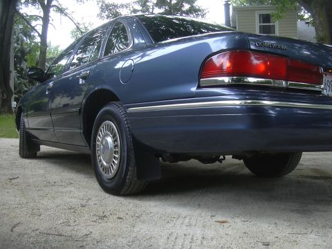 1996 Ford Crown Victoria - The rear quarter panel and taillight assembly of a blue 1996 Ford Crown Victoria are visible in this image.