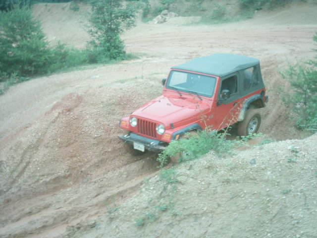 Red 2003 Jeep Wrangler on a dirt trail