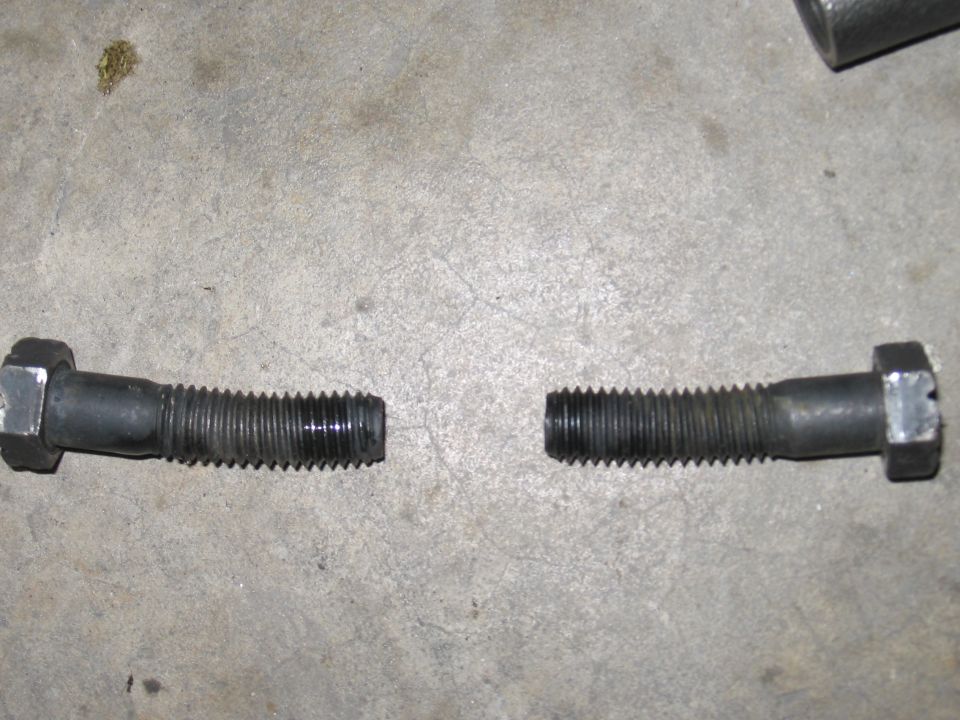 Two broken bolts on a concrete surface
