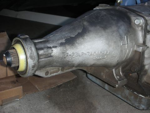 1998 Ford Crown Victoria - Side view of an aluminum automatic transmission extension housing cast with the Ford oval and part number RF-F3LP-7A040-AA, resting on card…
