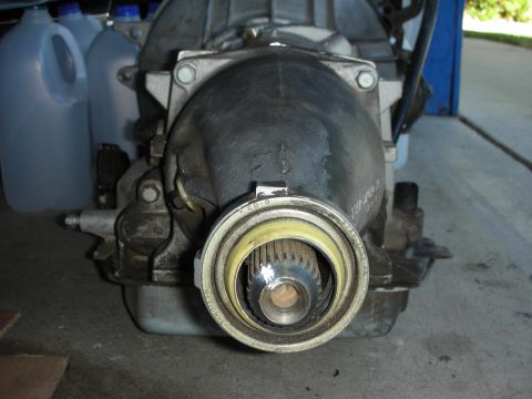1998 Ford Crown Victoria - Rear view of an automatic transmission sitting on the garage floor with the tailshaft housing pointing at the camera, showing the splined o…