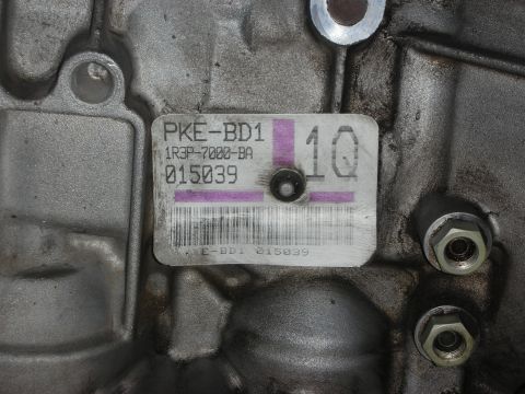 1998 Ford Crown Victoria - Close-up of a metal part with a label showing part numbers and a barcode.