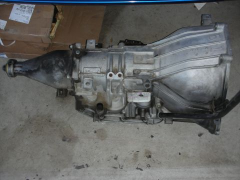 1998 Ford Crown Victoria - An automatic transmission is shown on a concrete surface, with boxes visible behind it.