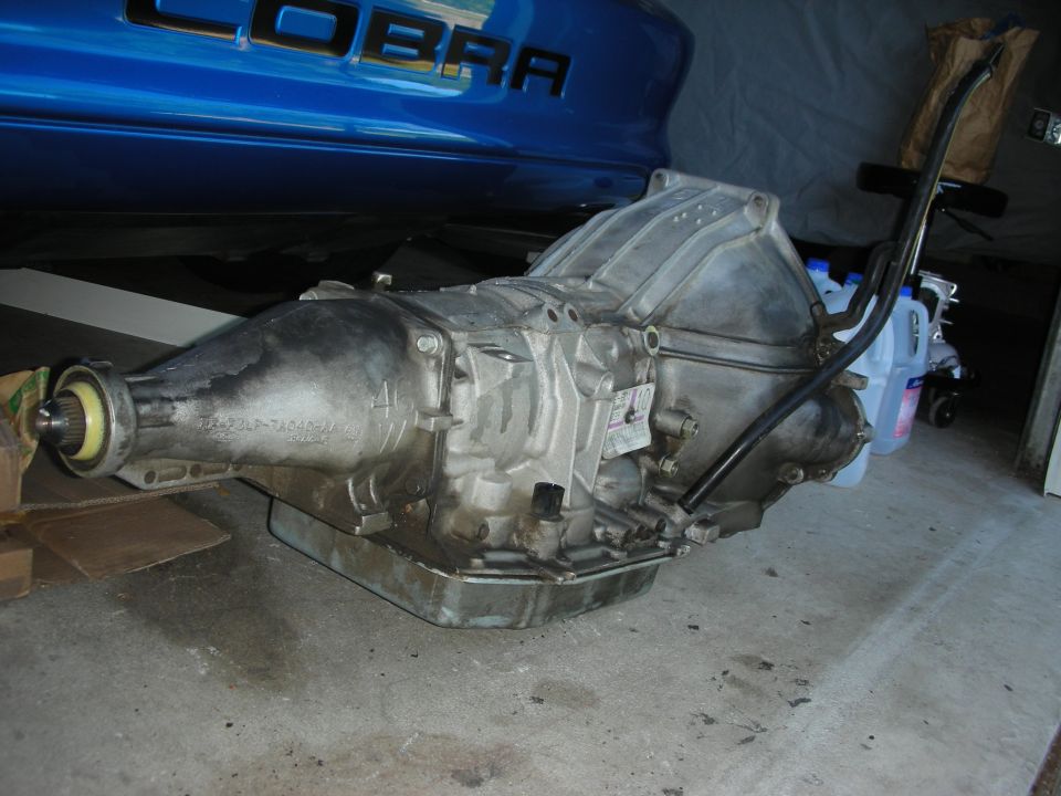Automatic transmission with "COBRA" lettering visible on a blue car in the background